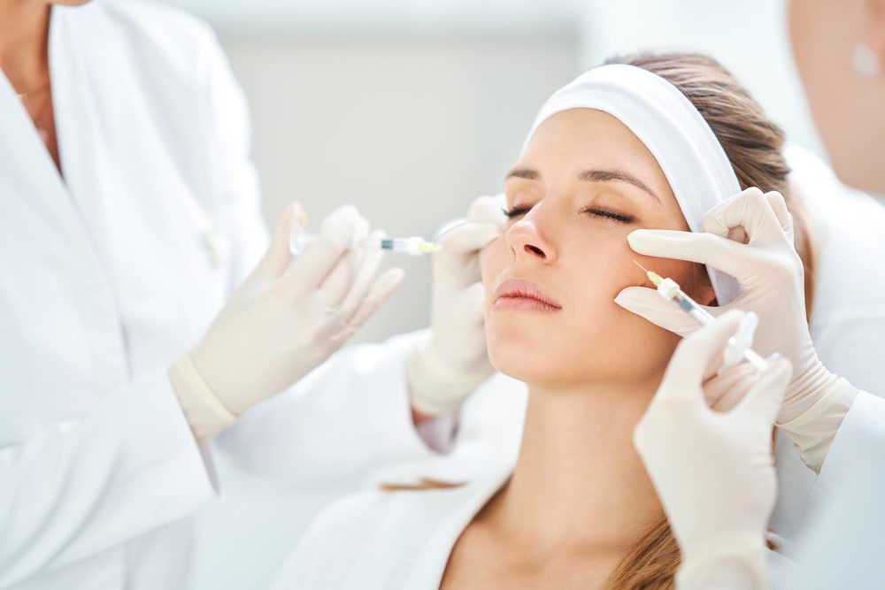 A woman receiving multiple cosmetic treatments at a medical spa.