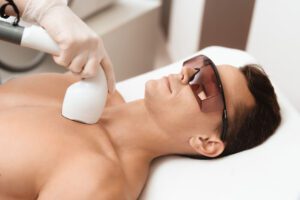 man getting laser hair removal on his chest with led blocking glasses