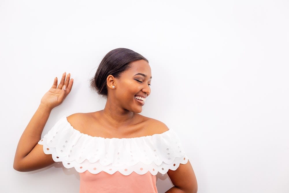 Woman smiling while leaning on wall